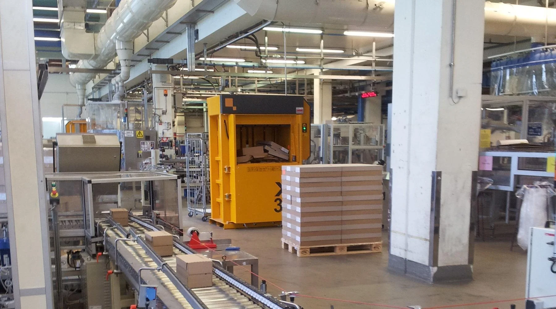 Production line operating in factory with a baler in the centre