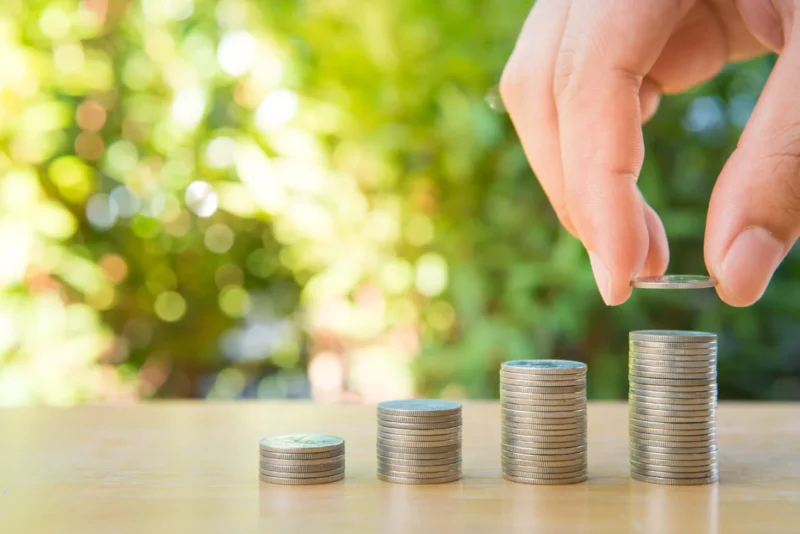 Coins stacked by hands