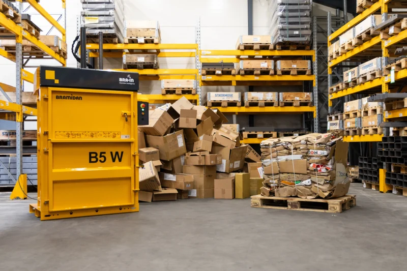 Vertical cardboard baler in warehouse